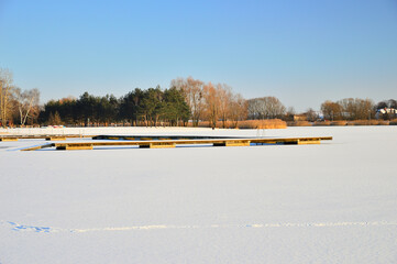 A frozen lake and pier on a frosty, sunny winter day.