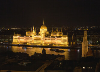 Fototapeta na wymiar Hungarian Parliament in night Pleasure boats moving on Danube