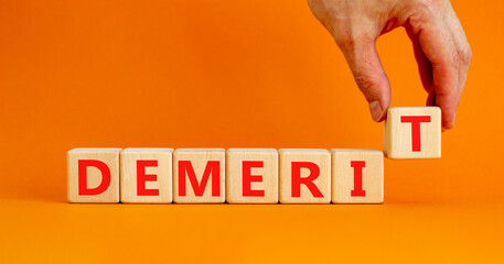 Demerit symbol. The concept word Demerit on wooden cubes. Beautiful orange table, orange...