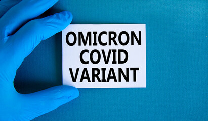 New covid-19 omicron variant strain symbol. Hand in blue glove with white card. Concept words...