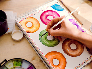Hand painting colourful doughnuts in water colour 