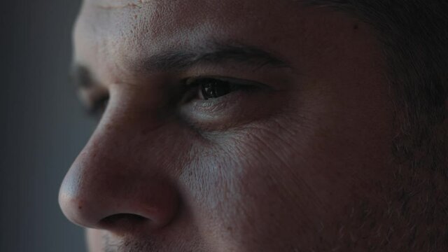 Extreme facial close up mature caucasian middle aged man 40s male eyes with wrinkles looking in distance out window thinking dreaming, enjoying good eyesight after successful laser correction operatio