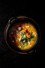 Pichelsteiner meat soup with vegetables in bowl on wooden table background top