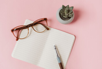 Carnet, stylo plume, lunettes et succulent sur fond rose pour trouver l'inspiration d'écrire, de...