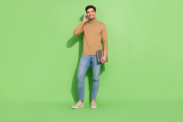 Photo of busy digital nomad travel guy hold pc have phone call wear beige shirt isolated green...