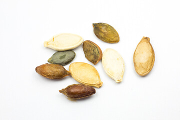 Different colorful  Dry Roasted Pumpkin seeds on white background. Tasty and healthy food. Close up photo.