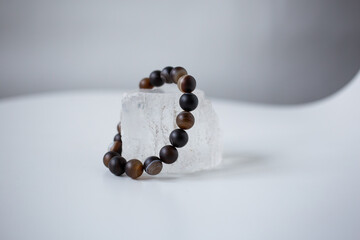 Beads from multi-colored natural stones lie on a snow-white stone, topaz and quartz