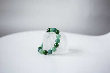 Beads from multi-colored natural stones lie on a snow-white stone, topaz and quartz