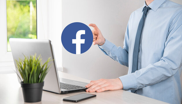 Onok,Ukraine - July 14,2021:Businessman holds, clicks, Facebook icon in his hands.Social network.global network and data customer connection.international network.