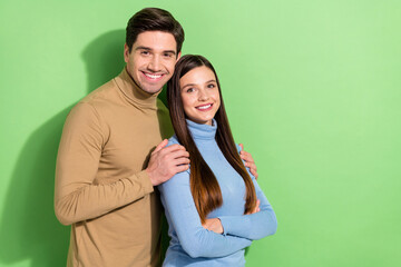 Portrait of two idyllic cheerful persons cuddle toothy smile look camera isolated on green color background