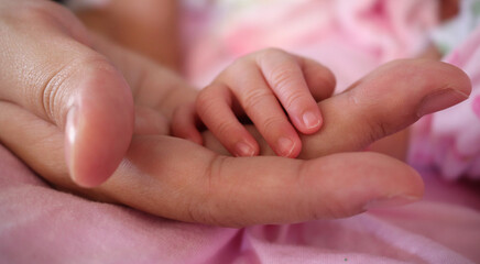 hand the sleeping newborn baby in the hand of mother close-up