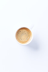 Cup of coffee on bright paper background. Top view. Close up. Copy space.	