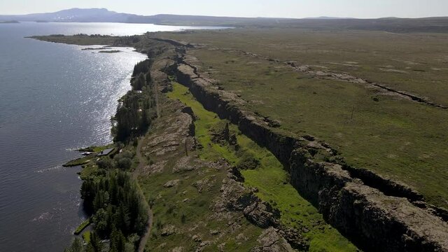 Cinematic aerial footage of Thingvellir national park, Iceland's parliament, the Thingvellir Church and the ruins of old stone shelters, hikes and lake in the golden circule