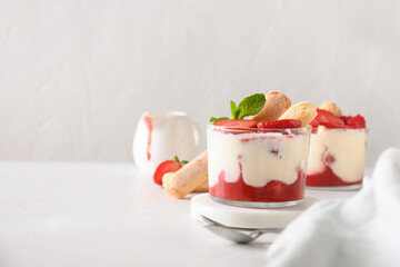 Layered strawberry trifle in glass jars with cookie savoyardi, mascarpone and whipped cream...