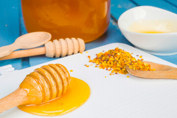 Honey with dipper, honeycomb and bee pollen on white background. 