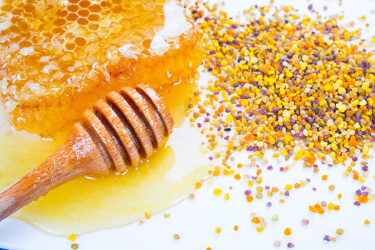 Honey with dipper, honeycomb and bee pollen on white background. 