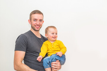 One year and three month boy in father's arms on white background