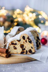 European pastry dessert with raisins, nuts, dried fruit and icing sugar. Christmas stollen pie and bokeh lights. Gluten off vegan dessert for winter holidays. Merry Christmas and Happy New Year.
