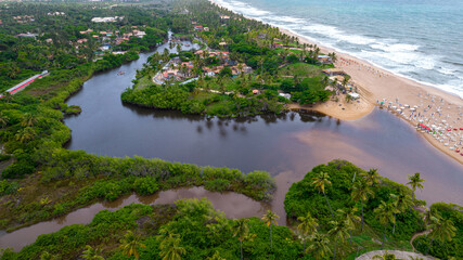 Aerial view of Imbassai beach, Bahia, Brazil. Beautiful beach in the northeast with a river and palm trees.