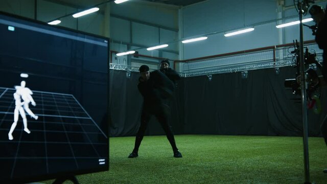 Cameraman filming actors performing some fight moves wearing motion capture suits as a game characters. Motion capture is an unparalleled method for making animated characters move more realistically