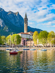 Bay of the city of Lecco in spring where we can see some boats.The road along the Lake with the walk and the tree-lined Avenue. - obrazy, fototapety, plakaty