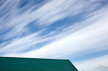 Fototapeta na wymiar Construction of the roof of the house. Metal tiles against blue sky