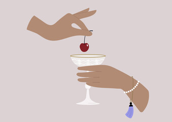 Hands putting a cherry in a champagne glass, upper class lifestyle