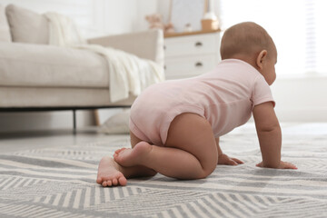 Cute baby crawling at home, focus on legs