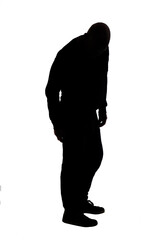 side view of the silhouette of a man wearing casual looking the floor