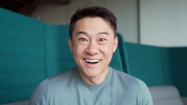 surprised asian man shoots glasses shocked looking at camera. Happy smiling rejoices. Look at monitor screen webcam view. amazed close up portrait. Face Handsome man Office worker wow expression