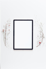 Creative arrangement frame made of cherry tree branches, natural dried cherry, foliage. Frame, flat lay, top view. Isolated tablet.