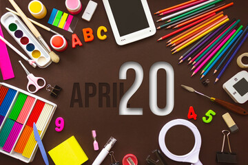 April 20th. Day 20 of month, Calendar date. School notebook and various stationery with calendar day. School and office supplies frame. Spring month, day of the year concept.