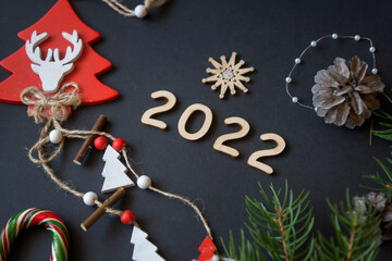 Christmas and New Year decorations, candies and fruits and wooden inscription Happy New Year. Wooden numbers for the new year 2022.