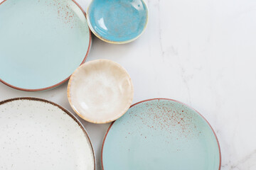 assorted ceramic plates on white marble table