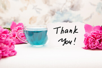Thank you card with bouquet of pink peony flowers and blue tea, beautiful thankfulness concept
