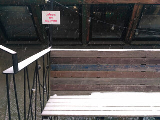 Obraz premium The place to sit is a bench covered with snow. The inscription in Russian 