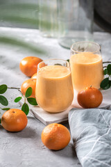A glass of tangerine smoothie with coconut milk