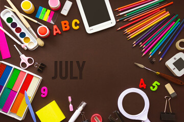 July. Month, Calendar month. School notebook and various stationery with calendar day. School and office supplies frame. Summer , month of the year concept.