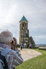 Obraz premium Blick über die Schulter eines Fotografen auf eine kleine Kapelle neben der Bagrati Kathedrale in Kutaissi, Georgien