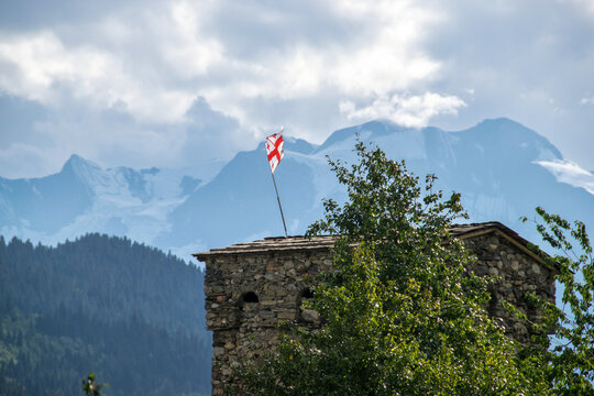 Blick auf einen Wehrturm in Mestia (Georgien) mit wundersch&ouml;ner Berglandschaft im Hintergrund
