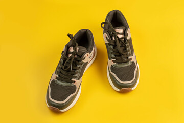 Pair of sports shoes on a yellow background. Top view.