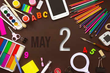 May 2nd. Day 2 of month, Calendar date. School notebook and various stationery with calendar day. School and office supplies frame. Spring month, day of the year concept.