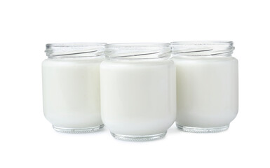 Glass jars with delicious homemade yogurt on white background
