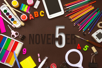 November 5th. Day 5 of month, Calendar date. School notebook and various stationery with calendar day. School and office supplies frame. Autumn month, day of the year concept.