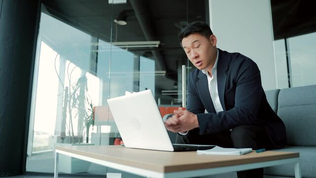 Asian male business partner talking remotely on video call using webcam. Businessman man in a suit entrepreneur, manager or office worker meeting online or conference. Chat with colleagues with laptop