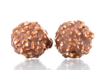 Two sweet chocolate candies with nuts, close-up, isolated on white.