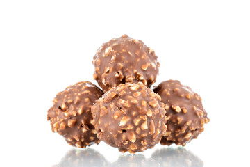 Several sweet chocolate candies with nuts, close-up, isolated on white.
