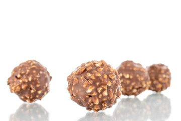 Several sweet chocolate candies with nuts, close-up, isolated on white.