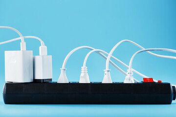 Surge protector with connected white wires of electrical appliances on a blue background.