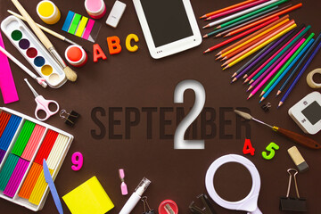 September 2nd. Day 2 of month, Calendar date. School notebook and various stationery with calendar day. School and office supplies frame. Autumn month, day of the year concept.